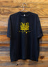 Holy Mountain Shirt Chromatic Coffee Black t shirt with yellow logo on a wooden background