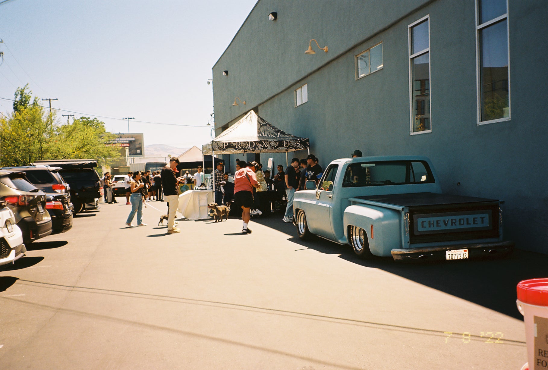 A Pop Up event outside Chromatic Coffee featuring a classic car and a tent with goods for sale