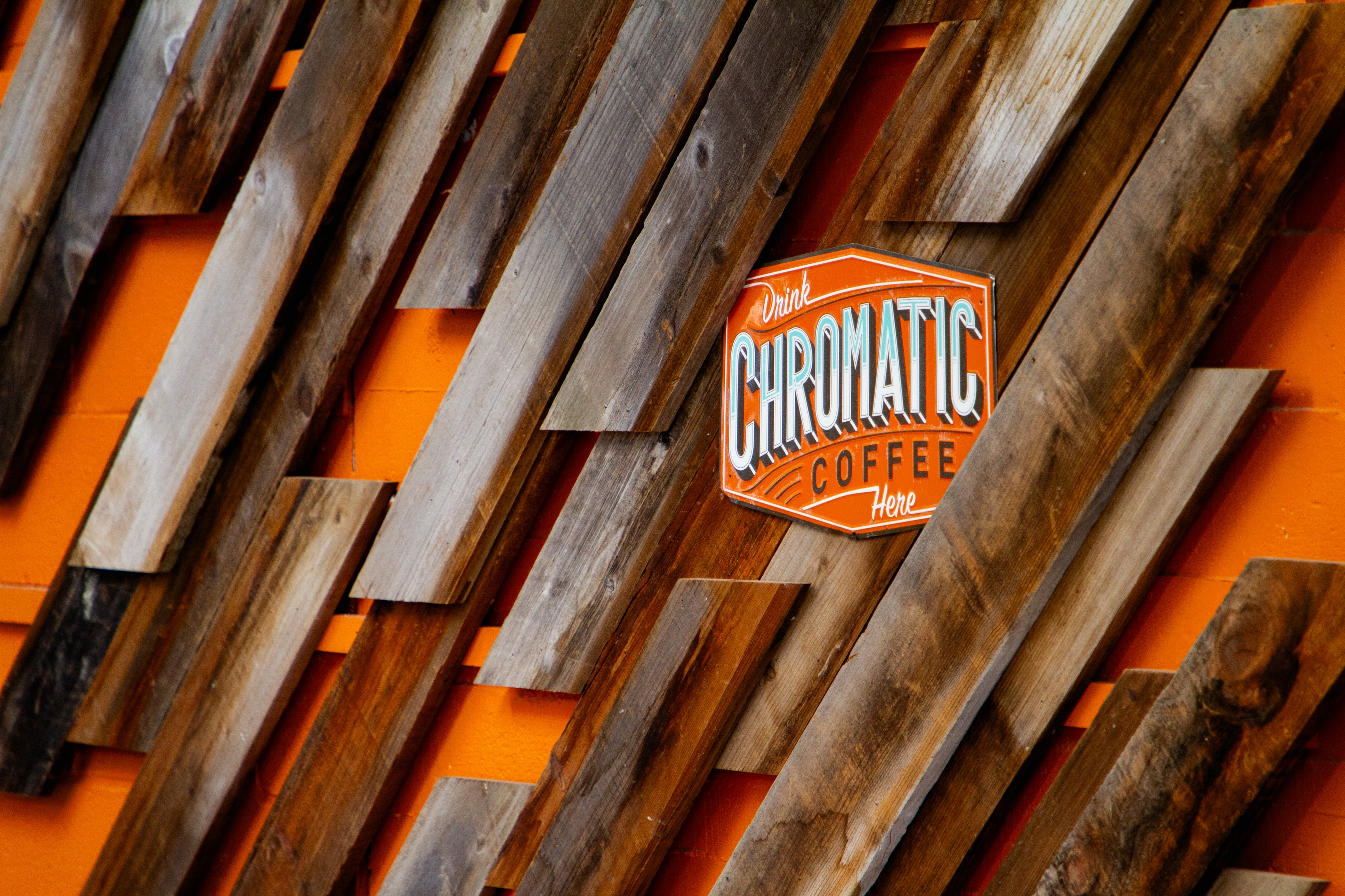 Photo of Chromatic logo on orange wood slatted wall