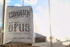 A pack of Opus Dark Roast coffee by Chromatic Coffee Co., standing in front of a window with a cloudy sky in the background.