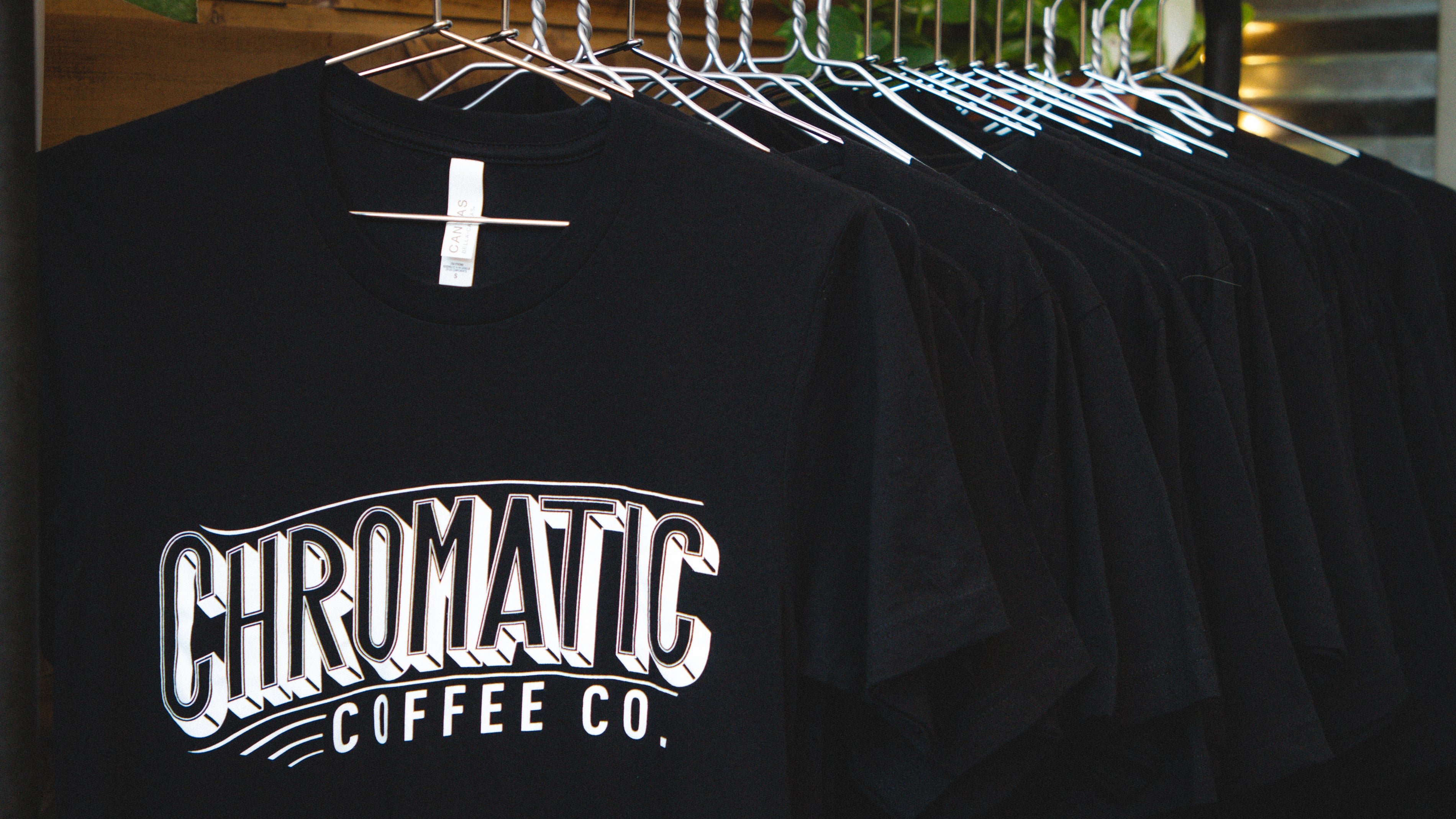 Chromatic Coffee t shirts in black hanging on a clothes rack