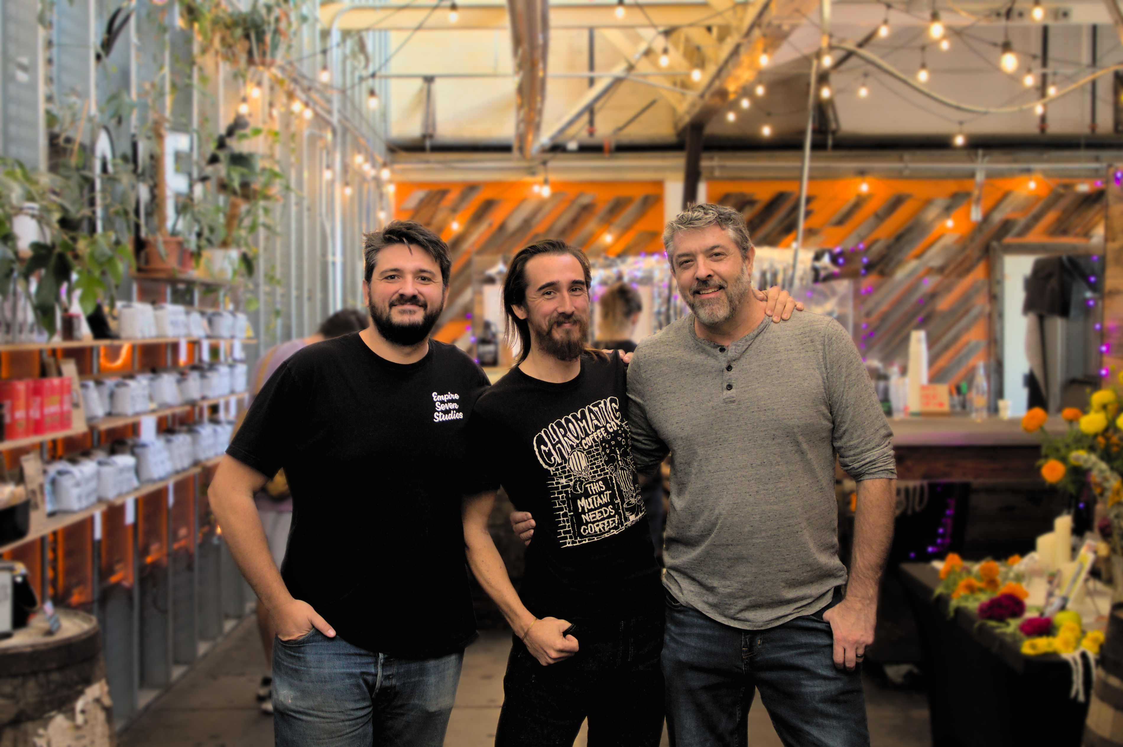 The founders of chromatic coffee smiling in front of a well lit cafe space