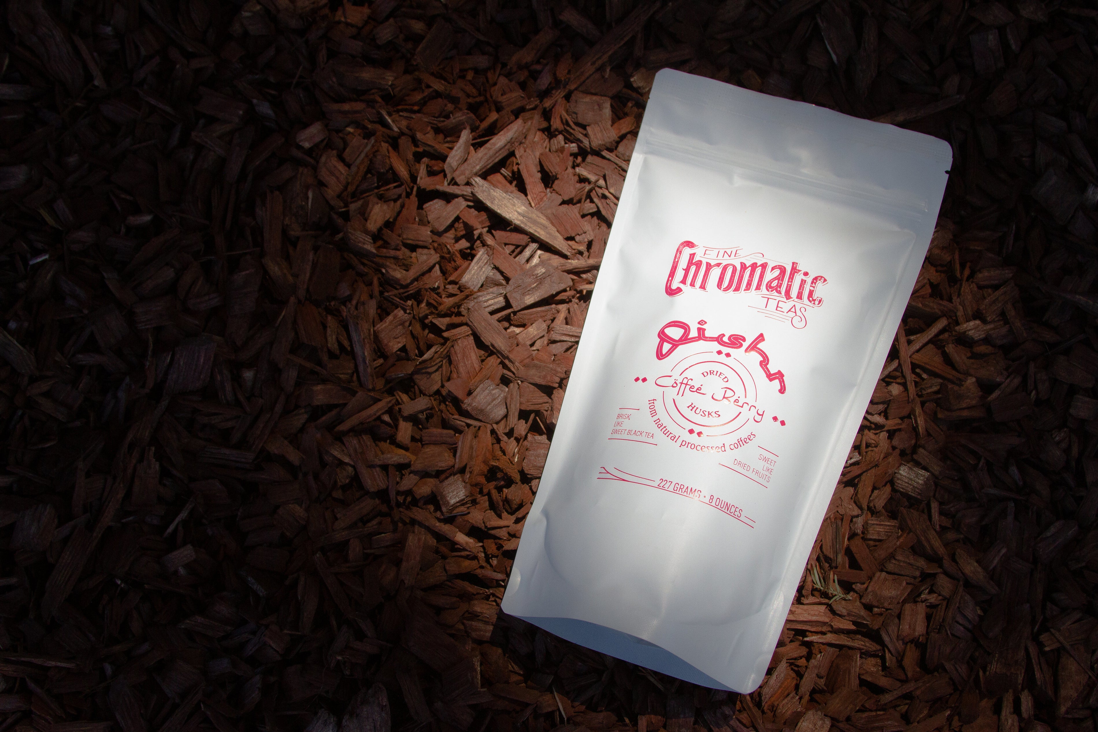 A packaged product labeled 'Chromatic Coffee' placed on a bed of coffee beans, with the brand name and product information visible.