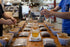 A table set up for a coffee tasting event with various bags of coffee and cups prepared for brewing.